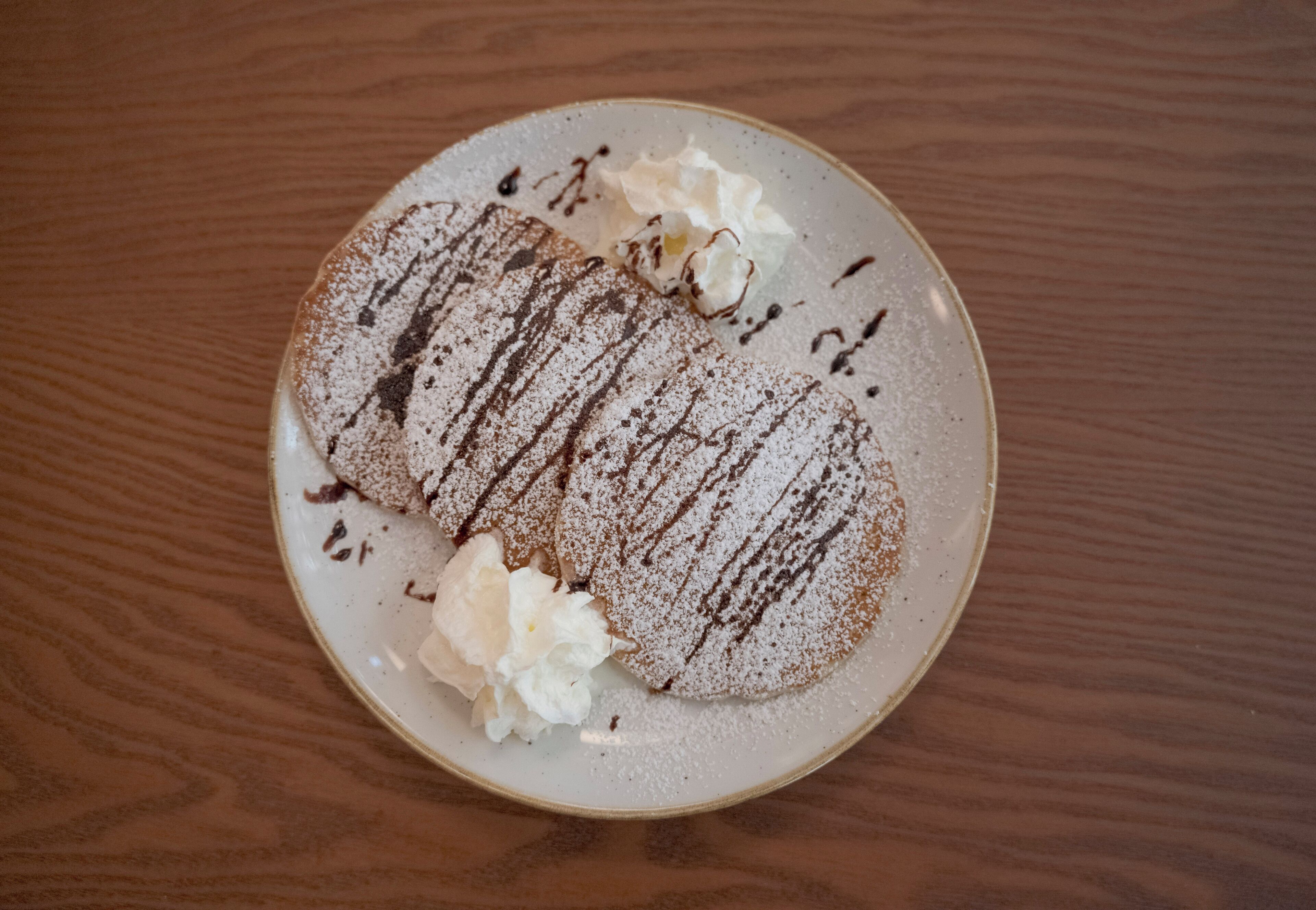 Een bord met dessert op een houten tafel.