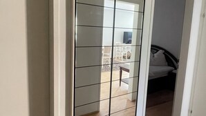 Ein Zimmer mit einer Schiebetür und einem Balkon mit Blick ins Freie.