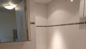Een badkamer met een wastafel, toilet en spiegel.