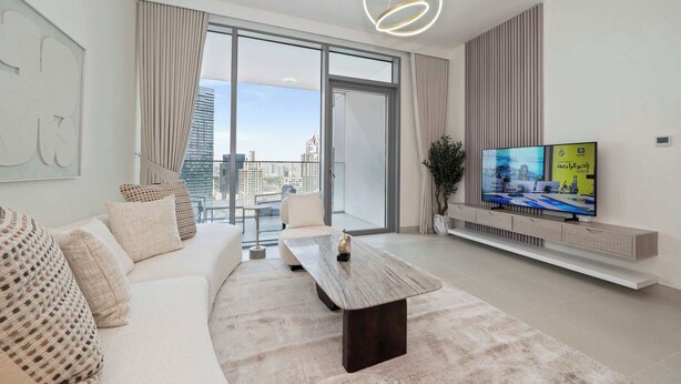 A modern living room with a large window, a flat-screen TV, a sofa, and a coffee table. - Luxury 1BR LIV Marina Modern with Marina View (Dubai)