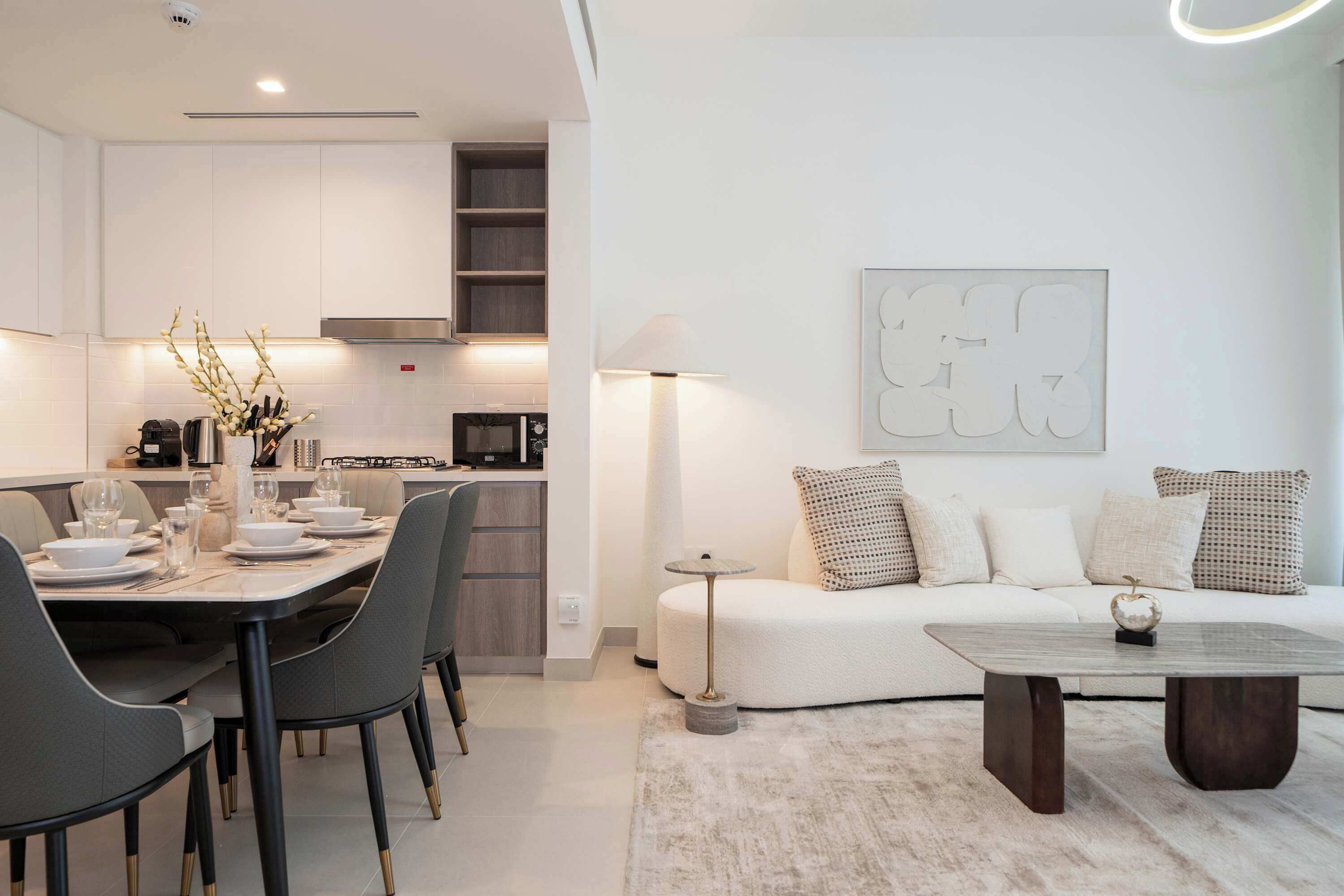 Een moderne woonkamer met een bank, salontafel en eethoek.