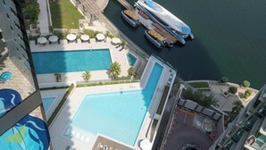 Ein Poolbereich auf dem Dach mit mehreren Pools, Liegestühlen und einer Anlegestelle für Boote.
