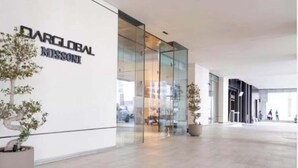 En moderne bygning med facade af glas og skilt med 'DARGLOBAL MISSION'.