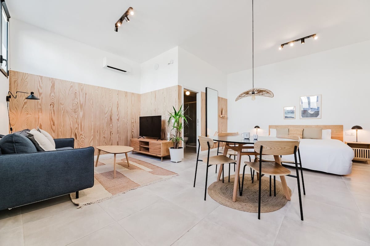 A modern living room with a sofa, dining table, and TV.