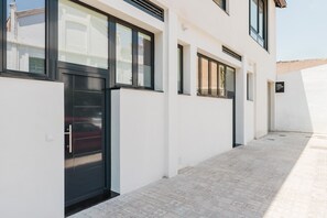 Un bâtiment moderne à la façade épurée, doté de grandes fenêtres et d’un sol carrelé.