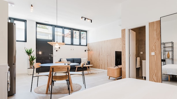 A modern interior with a dining area, sofa, and a bed. - Valencia Apartments by Olala Homes (València)
