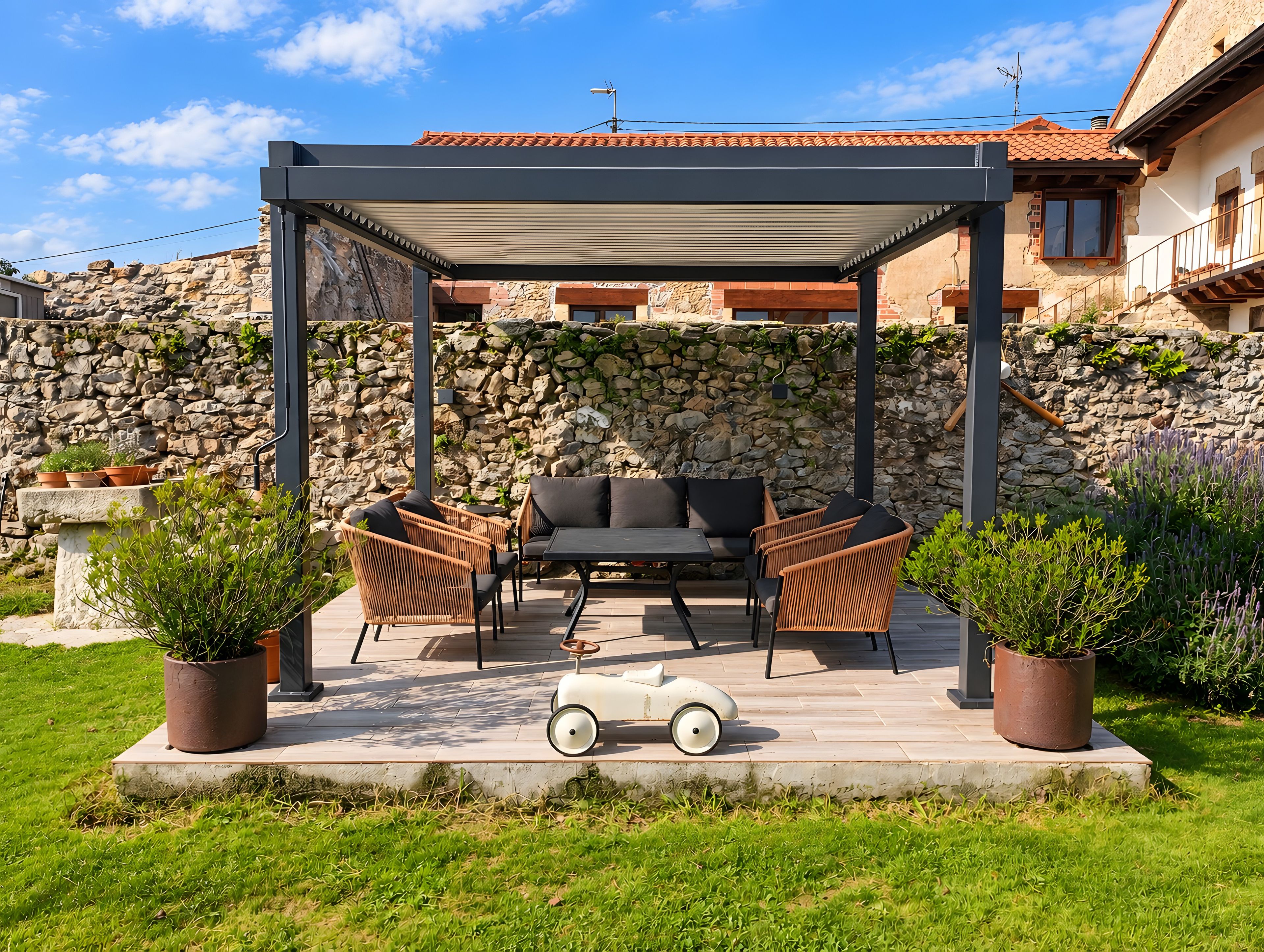 Un espacio de estar al aire libre con techo, mobiliario de mimbre y plantas en macetas.