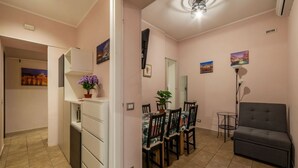 Un coin repas comprenant une table et des chaises, un canapé et une petite table avec une lampe.