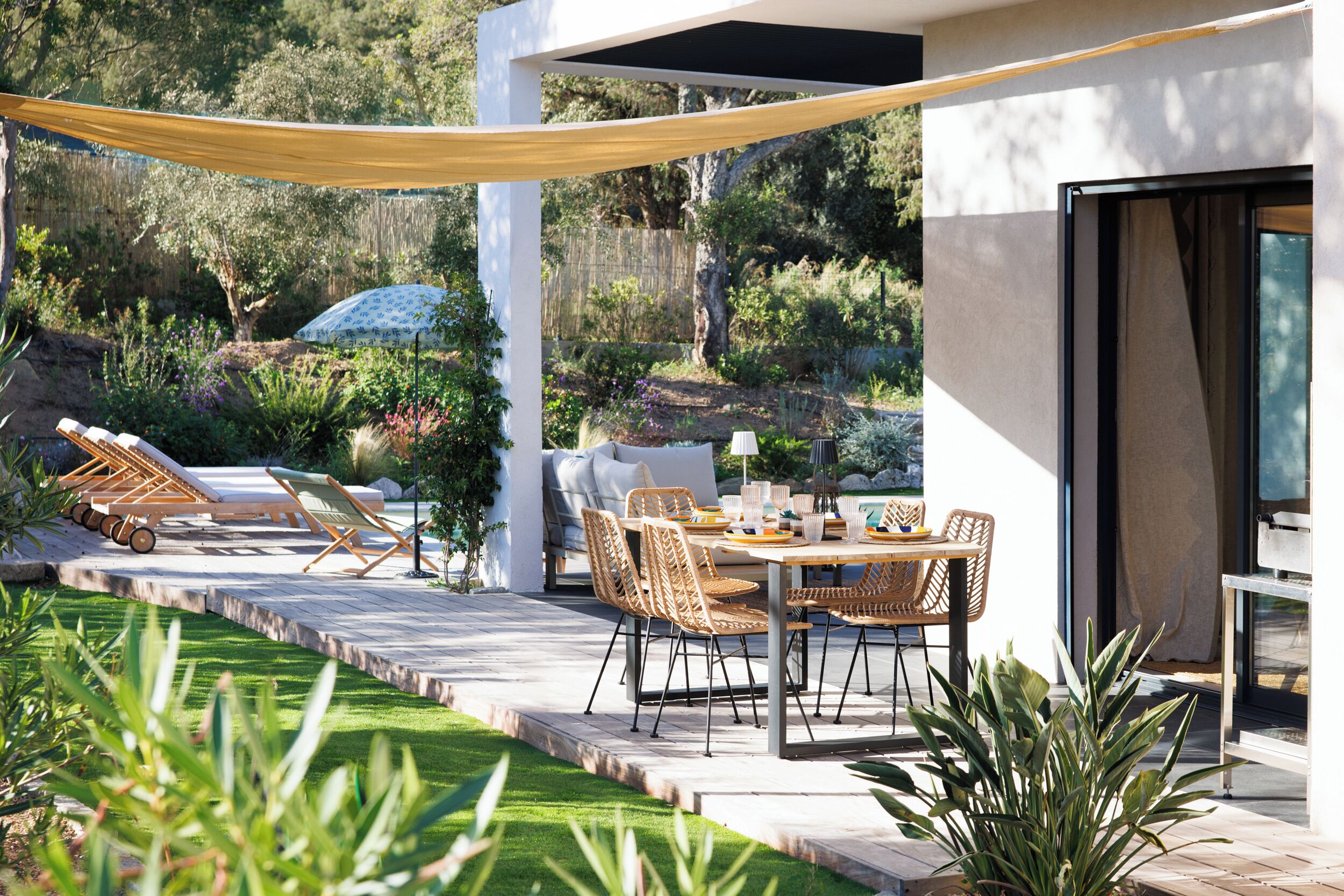 Un patio al aire libre con una mesa de comedor, sillas y sillones de descanso.