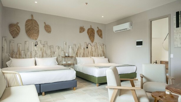 A hotel room with two beds, a desk, a chair, and decorative wall art. - w Ravishing 2BR in the Heart of Bocagrande (Cartagena)