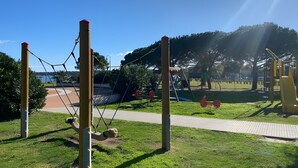 A playground with swings, climbing structures, and a walking path. - Holiday Home 'Porto San Paolo A 50 Mt Dal Mare' with Private Terrace, Wi-Fi and Air Conditioning (Porto San Paolo)