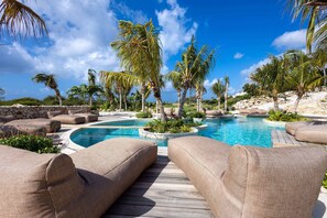 A pool area with lounge chairs and palm trees. - The Reef Superior Penthouse With Ocean View (Sint Michiel)