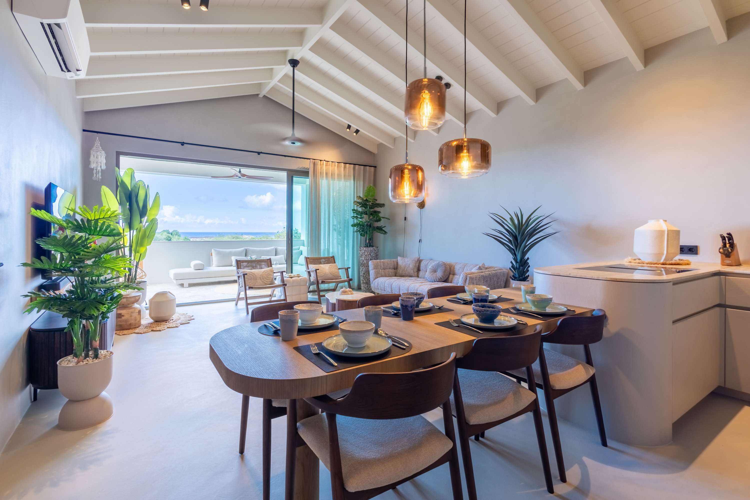 Un comedor moderno con una mesa grande, sillas e iluminación colgante.