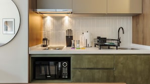 A modern kitchen with a built-in dishwasher, a coffee machine, and a sink with a black faucet. - w Dreamlike 1BR in the Heart of San Rafael (Mexico City)