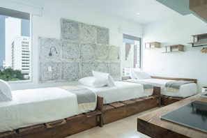 A modern hotel room with two wooden beds, a large window with a city view, and a wall decorated with circular patterns. - w Pleasant Loft in the Heart of Bocagrande (Cartagena)