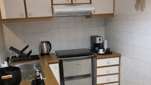 A compact kitchen with a sink, a coffee maker, a kettle, and a refrigerator. - Athens Cozy Nest - Prime Central Location (Athens)