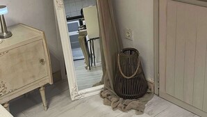 A room with a large mirror, a small table, and a chair. - Athens Cozy Nest - Prime Central Location (Athens)