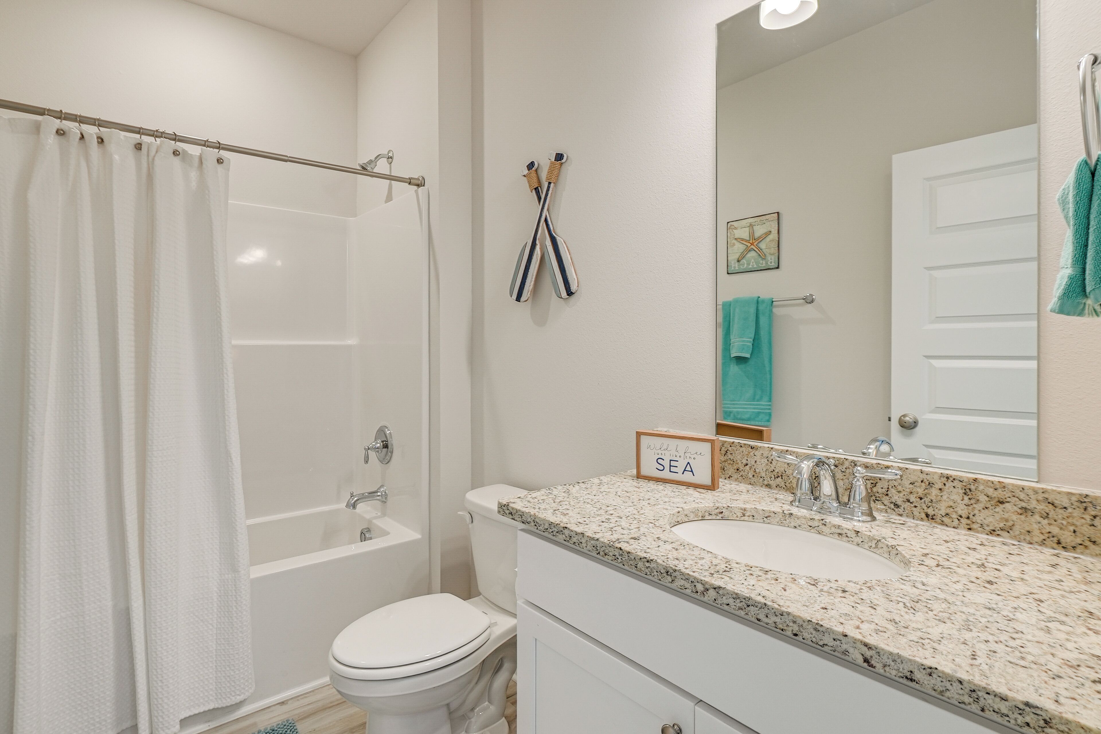 Une salle de bain avec une baignoire, des toilettes, un lavabo et un miroir.