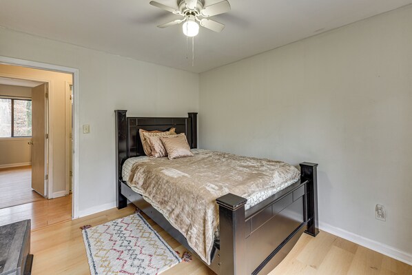 A bedroom with a bed, a ceiling fan, and a rug. - Group-friendly Home w/ Yard in Charlotte Suburbs! (Charlotte)