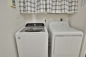 Un espace buanderie équipé d’un lave-linge et d’un sèche-linge à chargement frontal.
