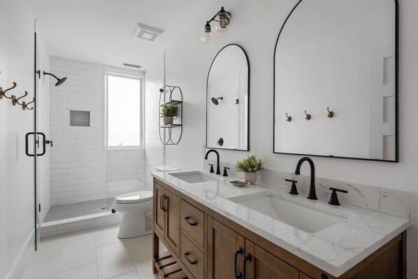 A modern bathroom with a large vanity, a shower, and a toilet. - RENOVATED, DOG FRIENDLY 3 BEDROOM COTTAGE IN REHOBOTH BEACH (Rehoboth Beach)