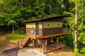 Eine Holzdiele mit einem Balkon, einer Treppe und einem eingezäunten Bereich.