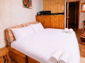 A bed with white linens, a wooden headboard, and two rolled towels. - Apartment near slopes with balcony, valley view (Méribel)