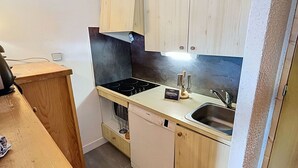 A compact kitchen with a dishwasher, a sink, and a stove. - Apartment near slopes with balcony, valley view (Méribel)