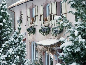 A building with multiple windows, some adorned with greenery and lights. - Cozy cottage with private garden near Saint-Dié-des-Vosges (Provenchères-et-Colroy)