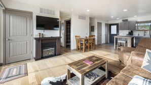 A spacious living area with a fireplace, a dining table, and a sofa.
