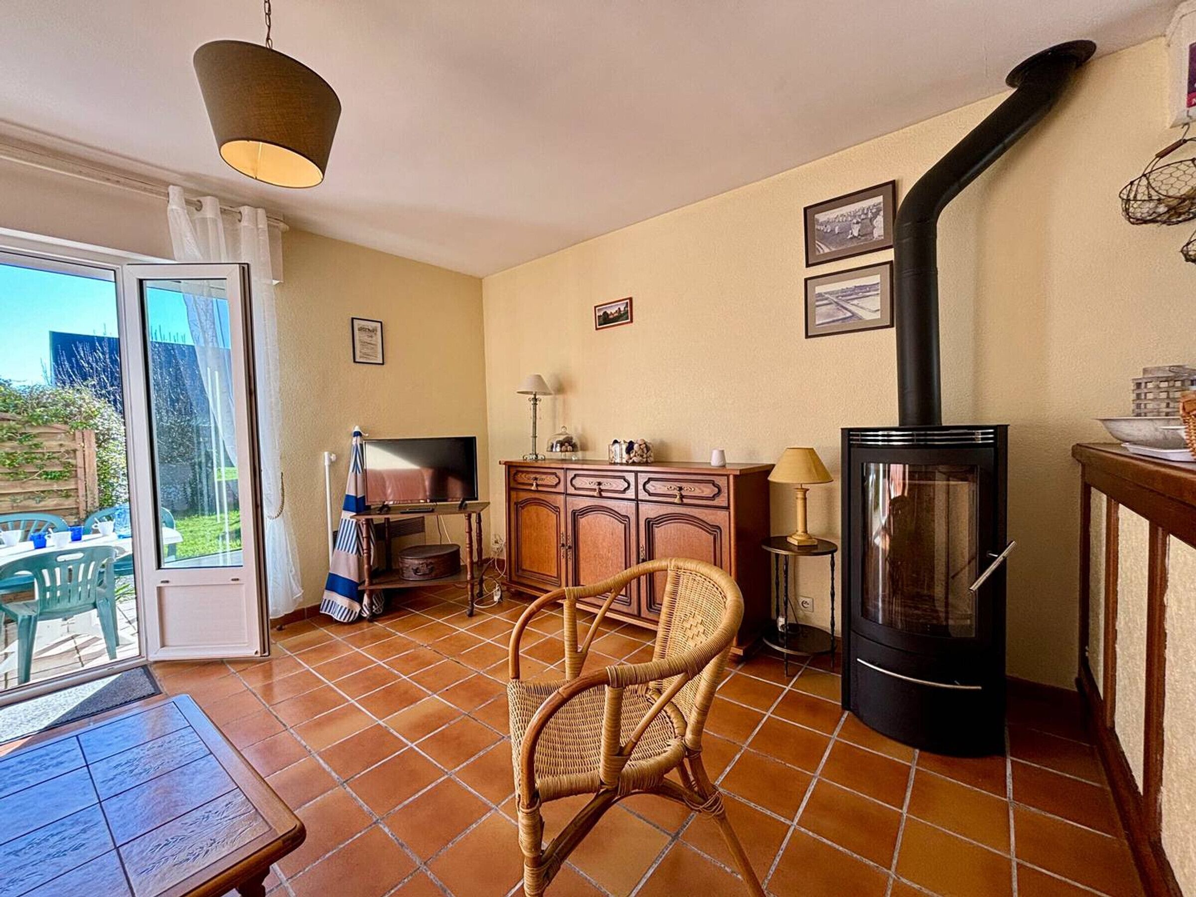 A cozy living room with a fireplace, a dining area with a table and chairs, and a television on a wooden cabinet.