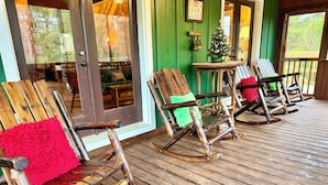 Une terrasse en bois avec des fauteuils à bascule et une petite table.