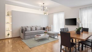 A modern living room with a sofa, coffee table, and dining area. - Acropolis Vibe Residence, Acropolis Vibe Residence (Athens)