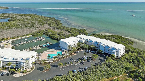Un resort con varias edificaciones, un puerto deportivo y un estacionamiento.