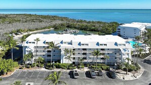 A beachfront hotel with multiple floors, a swimming pool, and a marina.