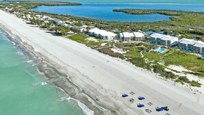 An aerial view of a coastal hotel with multiple buildings, a beach, and nearby mangrove islands. - Beach Villa 2007 - beautifully renovated one-bedroom, one-bathroom condo (Captiva)