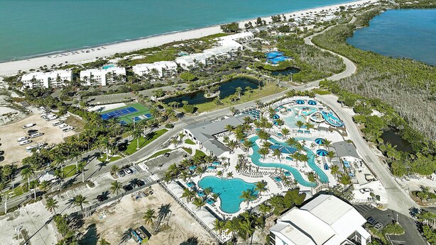 An aerial view of a resort with multiple swimming pools, a beach, and a marina. - Beach Villa 2007 - beautifully renovated one-bedroom, one-bathroom condo (Captiva)