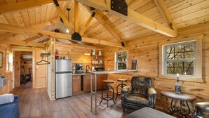 L’intérieur d’un chalet en bois comprend une cuisine, un coin repas et un espace salon.
