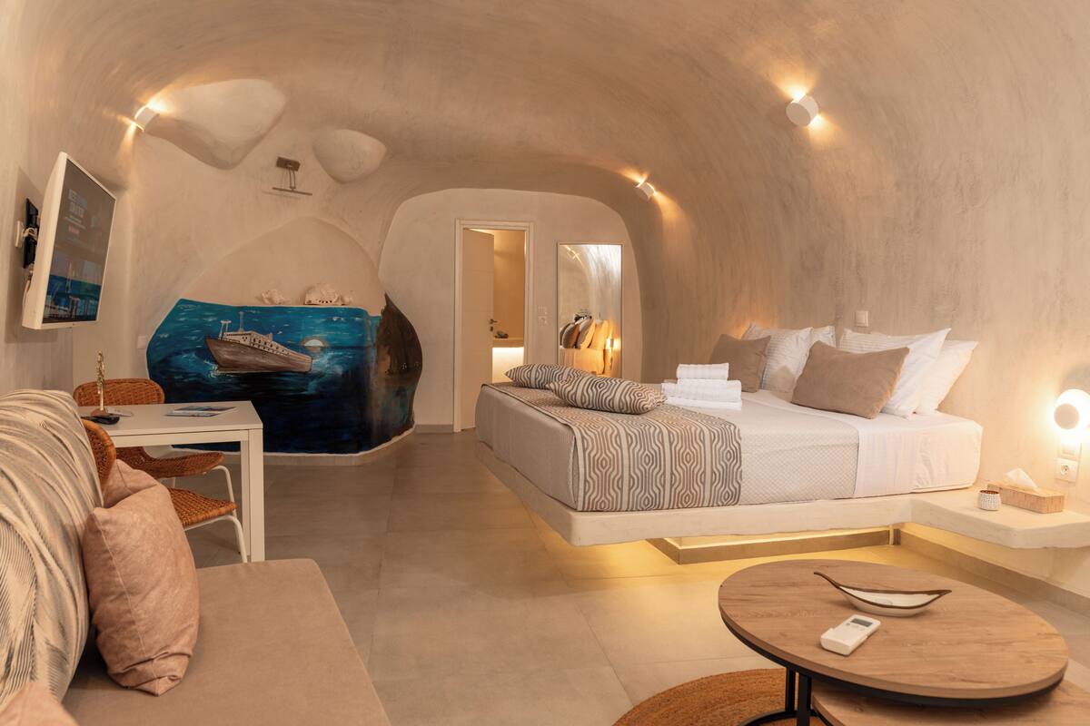A cozy bedroom with a bed, bedside table, and a unique ceiling design.
