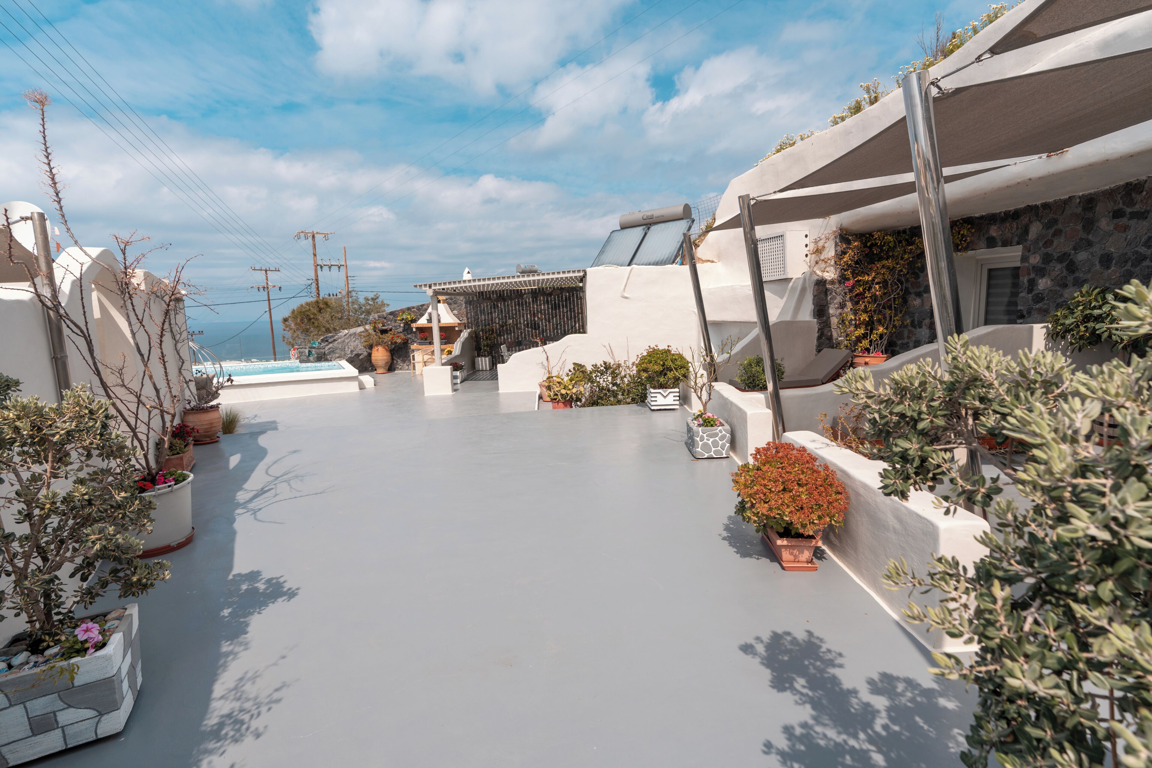 Una calle residencial con casas, plantas en macetas y cielo despejado.