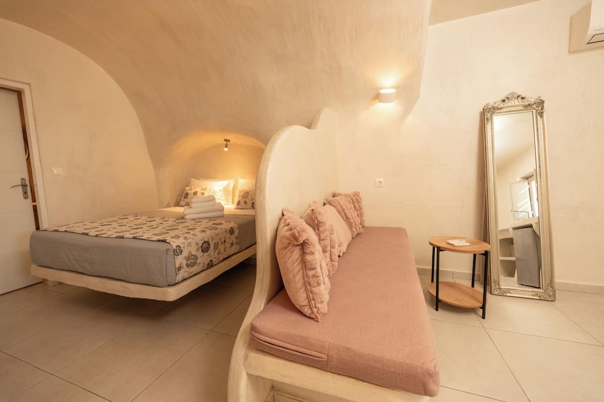 A bedroom with two beds, a mirror, and a small table.