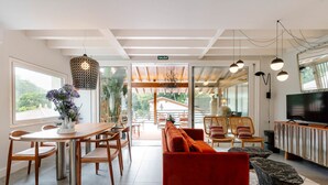 Un intérieur moderne avec un coin repas, un canapé rouge et un téléviseur.