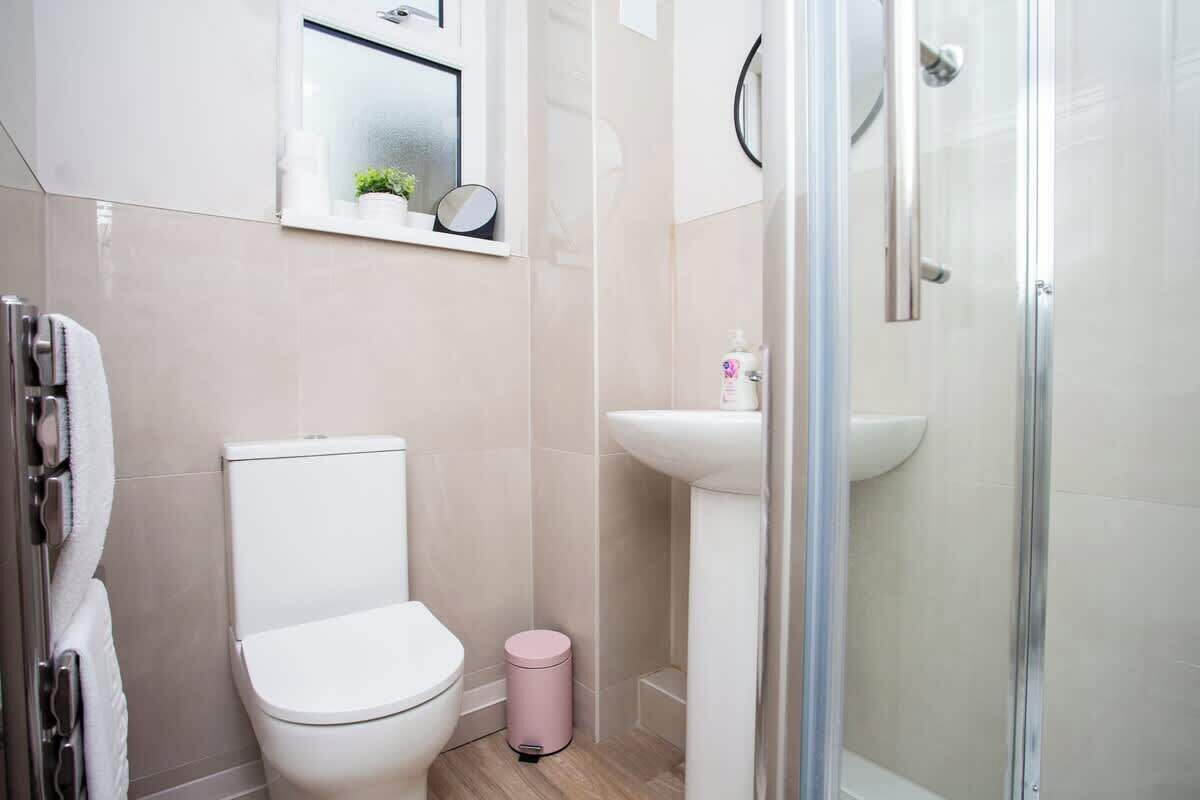 A bathroom with a toilet, sink, and shower.