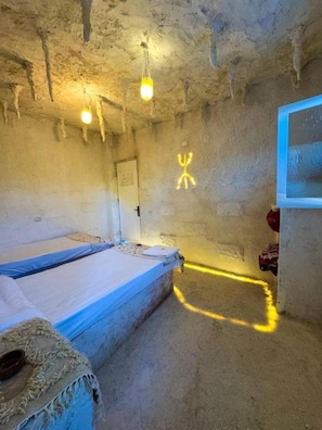Ein Zimmer mit einem Etagenbett, einer Tür und einer Wand mit einem Neonzeichen.