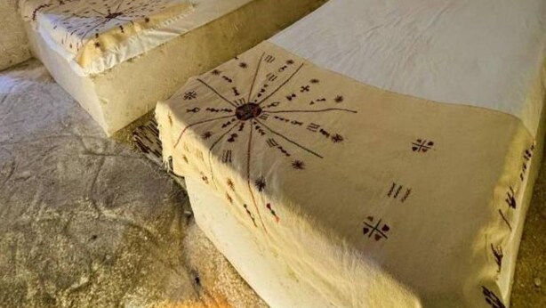 Una habitación tipo cueva con dos camas, cada una con un edredón de diseño único.