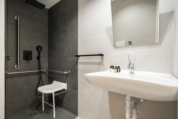 A modern bathroom with a shower, grab bars, a white sink, and a mirror. - Dobo Madrid SB20 (Madrid)