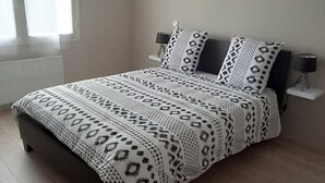 Une chambre à coucher avec un lit, une fenêtre et un ventilateur de plafond.