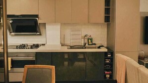 Une cuisine moderne équipée d’un four à micro-ondes encastré, d’une cuisinière à gaz et d’appareils électroménagers en acier inoxydable.