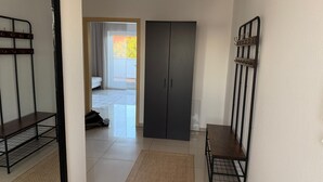Ein Flur mit Schrank, Sitzbank und Kleiderhaken.