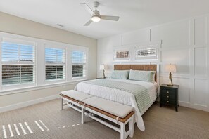 A bedroom with a bed, bench, nightstand, ceiling fan, and large windows. - Dennis -- Brand New in 2026! (Corolla)